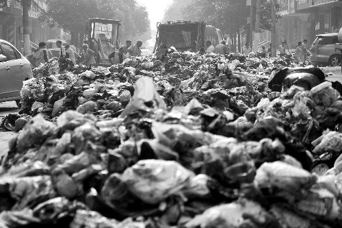 垃圾堆滿整個路口，環(huán)衛(wèi)工人們正在清理