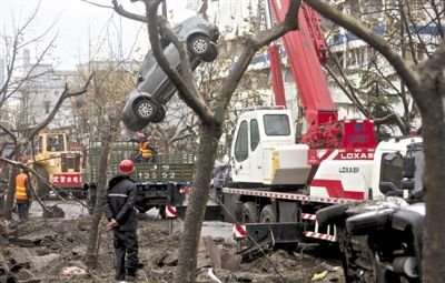 輸油管道爆炸后，搶修人員將被炸毀的車輛運(yùn)出現(xiàn)場。