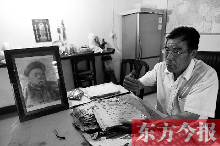 　魏樹紹手拿《物權(quán)法講義》手稿，在講訴先祖書寫“物權(quán)法”的歷史（相框里就是魏聯(lián)奎）