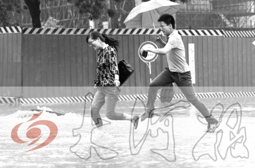 鄭州經(jīng)三路與北環(huán)交叉口處，積水較深，行人們不得不“練輕功”。 記者 白周峰 攝影