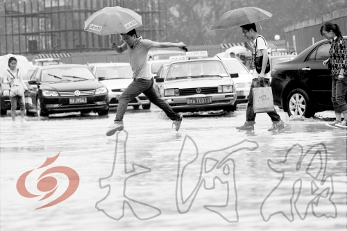 鄭州經(jīng)三路與北環(huán)交叉口處，積水較深，行人們不得不“練輕功”。 記者 白周峰 攝影