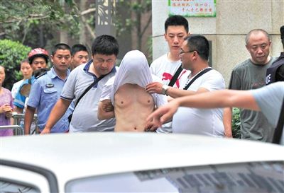 昨日，成都警方抓捕時與毒犯發(fā)生槍戰(zhàn)。一名男犯罪嫌疑人被警方押出。
