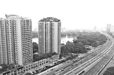 昨日，人濟(jì)山莊小區(qū)，與其他樓相比，B棟樓頂層天臺上違規(guī)建造了一棟兩層小樓，假山大樹俱全。新京報(bào)記者