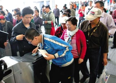 去年5月5日，14號線園博園站，乘客刷卡出地鐵。北京公交地鐵將實行計程票制，多乘坐多付費。