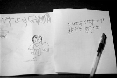 名叫袁明燕的小姑娘用筆在紙上不斷寫“媽媽”二字。