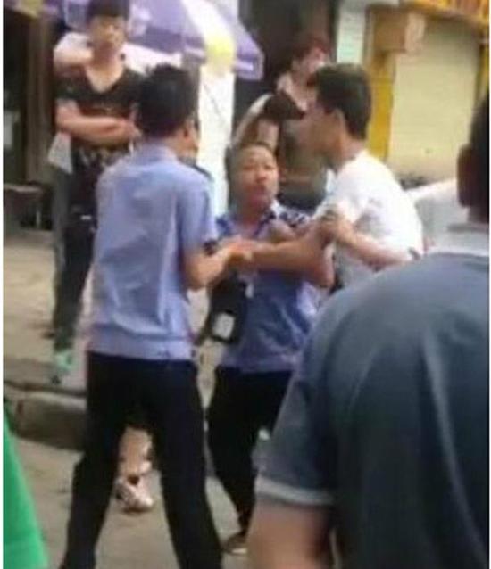 付某（右）與城管執(zhí)法人員廝打在一起。