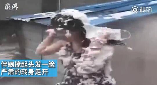 視頻中可以看到，雖然伴娘事先有穿雨衣防備，但在被伴郎團圍攻時，雨衣被拔下，更過分的是，有人還用滅火器直接對著她的臉噴。后來伴娘好像是生氣了，撩起頭發(fā)一臉嚴肅的轉(zhuǎn)身走開。