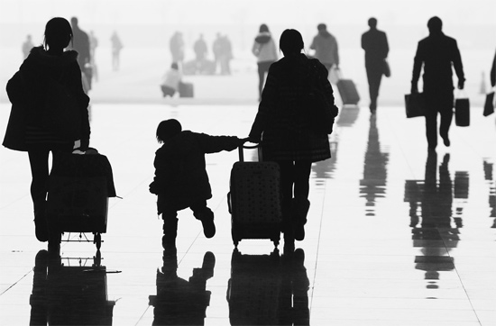 昨日，鄭州東站，一名孩子拉著媽媽和包裹快樂(lè)地奔走在春運(yùn)的途中