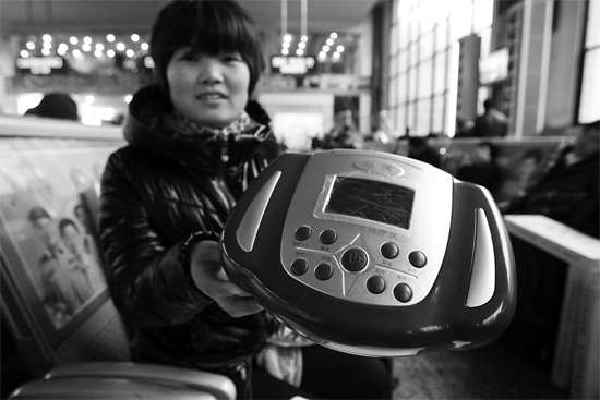 火車(chē)站候車(chē)室，李女士向記者展示她準(zhǔn)備孝敬父母的按摩儀