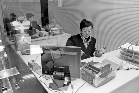 2月16日，鄭州市自來水總公司鄭東新區(qū)一營業(yè)廳，柜臺內(nèi)工作人員正在為市民辦理業(yè)務