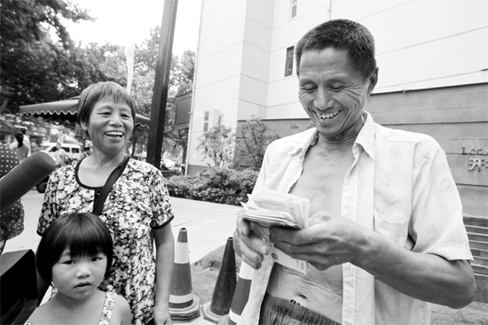 昨日，鄭州市明達(dá)路與豐慶路交叉口西300米路南，來自中牟的瓜農(nóng)拿到西瓜款，笑開顏東方今報(bào)記者袁曉強(qiáng)