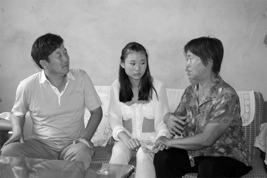 “商丘最美女兒”李丹（中）捐骨髓救母，愛(ài)心人士（左）送來(lái)1萬(wàn)元愛(ài)心款