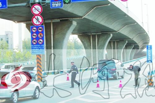 交警在東風(fēng)路從北向南上橋口處擺上反光錐，間歇放行