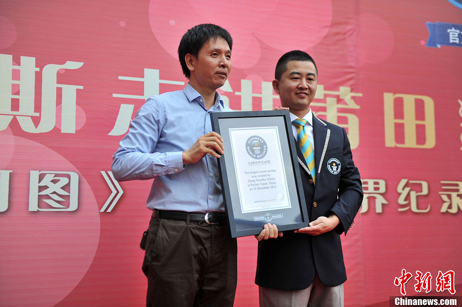 圖為世界吉尼斯認(rèn)證官為鄭春輝（左）頒發(fā)證書。呂明 攝