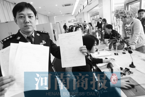 　民警左手拿的是新申請表，右手拿的是三份老申請表 王春勝/攝