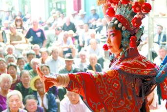 圖為8月15日戲曲演員在“流動舞臺車”上表演傳統(tǒng)地方戲《穆桂英下山》。