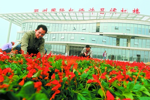 9月23日，工人們正在鄭州國際機場許昌候機樓前擺放鮮花。