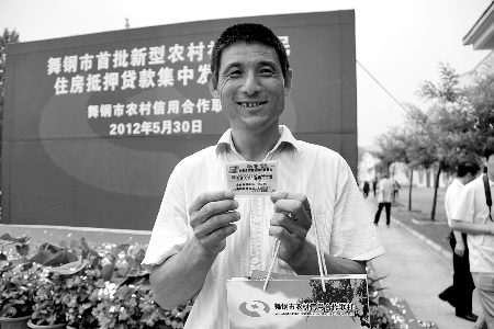 領(lǐng)到貸款，農(nóng)民開心地笑了。