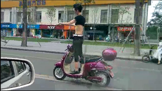 奇葩男子電動(dòng)車上秀雜技 戴墨鏡大撒把