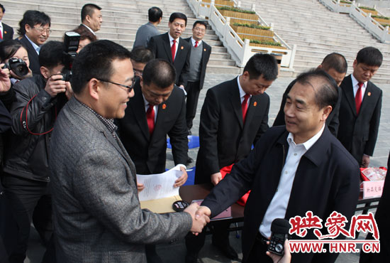 在新密市法院，省高院院長張立勇為拍得轎車的陳先生發(fā)放車鑰匙。