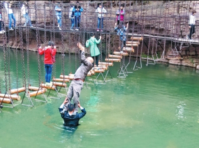 中年男游客正踩著景區(qū)安全員郭小明的肩膀過(guò)河。網(wǎng)友“@我的小名叫張孩”供圖