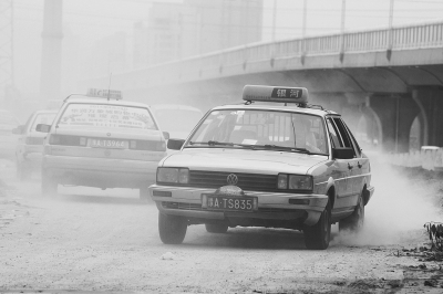 施工的道路上，車輛通過塵土飛揚。