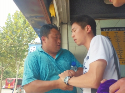 記者正查看照片，突遭藍(lán)衣男強(qiáng)搶手機(jī)。