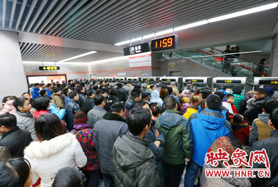 地鐵開通首日，上午十一點五十九分，紫荊山地鐵站售票機前擠滿了買票的市民。