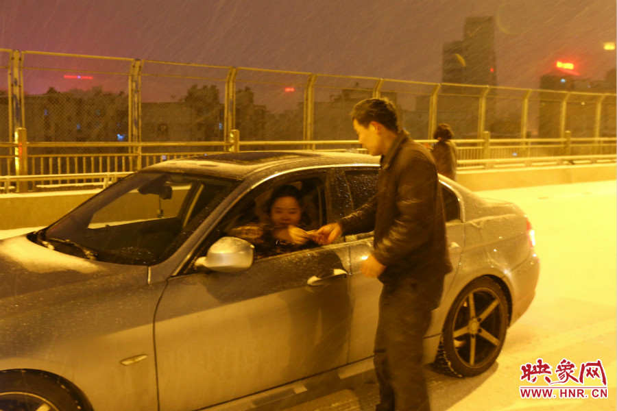 “推車人”幫助一輛車上坡后，收取“勞務(wù)費(fèi)”。