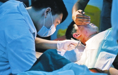 孩子身上有7道傷痕，其中兩道需要縫合，其他的均為擦傷，醫(yī)生正對他施治。