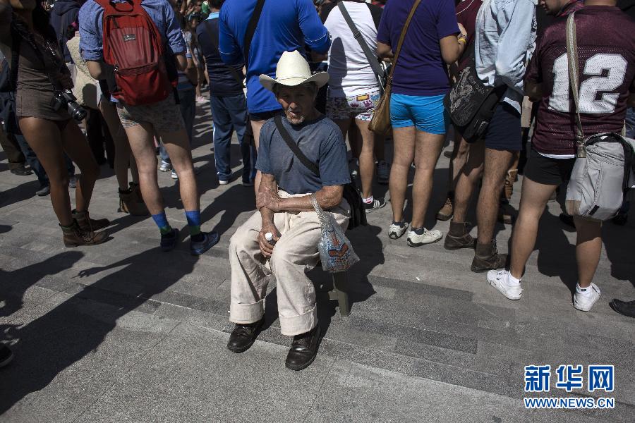 一名男子坐在參加不穿褲子搭地鐵的人群邊小憩。
