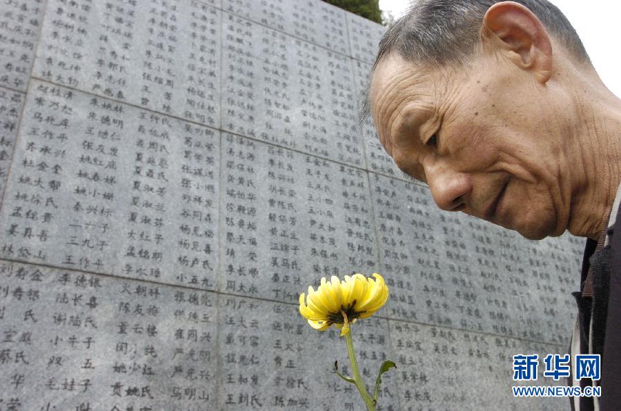 2006年4月5日，74歲的南京大屠殺幸存者佘子清手捧鮮花，祭奠被日軍殺害的母親。