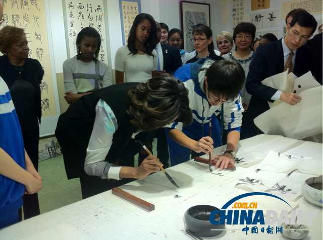 　北京時間3月21日，美國第一夫人米歇爾參觀北師大二附中時，與學(xué)生一起練習(xí)書法。