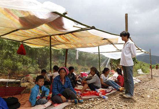 暴雨馬上來(lái)臨，村民們?cè)诤?jiǎn)易帳篷下躲雨。澎湃新聞 程藝輝 圖