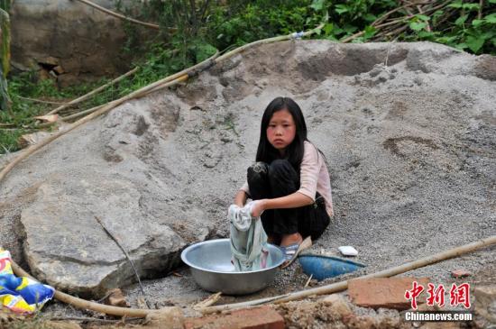 8月9日，云南巧家紅石巖村，10歲的劉鑫蕊在洗自己的衣服