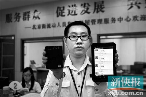 　越秀區(qū)北京街出租屋外來(lái)暫住人員管理服務(wù)中心的工作人員展示到出租屋登記來(lái)穗人員信息的儀器。