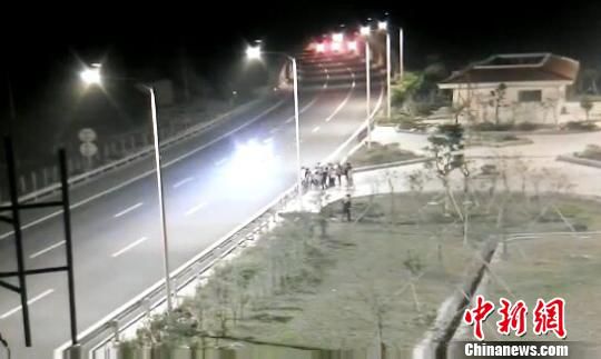 看到車輛經(jīng)過，孩子們便急忙跑到一旁的花圃上?！【焦﹫D　攝