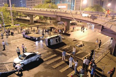 路虎沖下國貿(mào)橋砸中一輛起亞轎車，橋上厚達(dá)幾十厘米的水泥護(hù)欄被撞斷，碎石四處散落，數(shù)十群眾在現(xiàn)場圍觀。