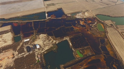 4月19日，廊坊市大城縣南趙扶鎮(zhèn)，津保路以北約八九百米處，一個(gè)巨大的污水坑中，水體呈現(xiàn)紅褐色。 新京報(bào)記者 尹亞飛 攝