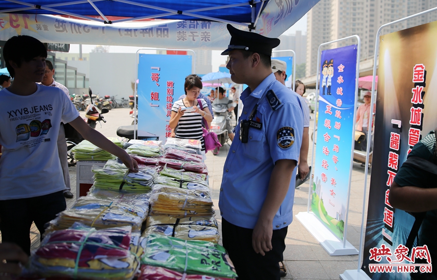 執(zhí)法人員勸導(dǎo)看守?cái)偽坏娜藛T搬離，停止非法占道經(jīng)營(yíng)。