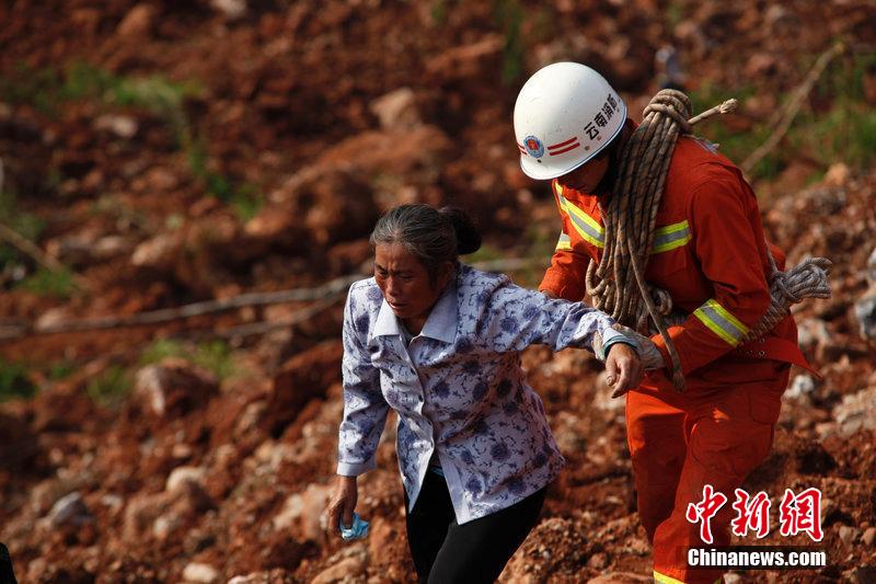 一位消防戰(zhàn)士將一位失去親人的老人扶離滑坡點(diǎn)。