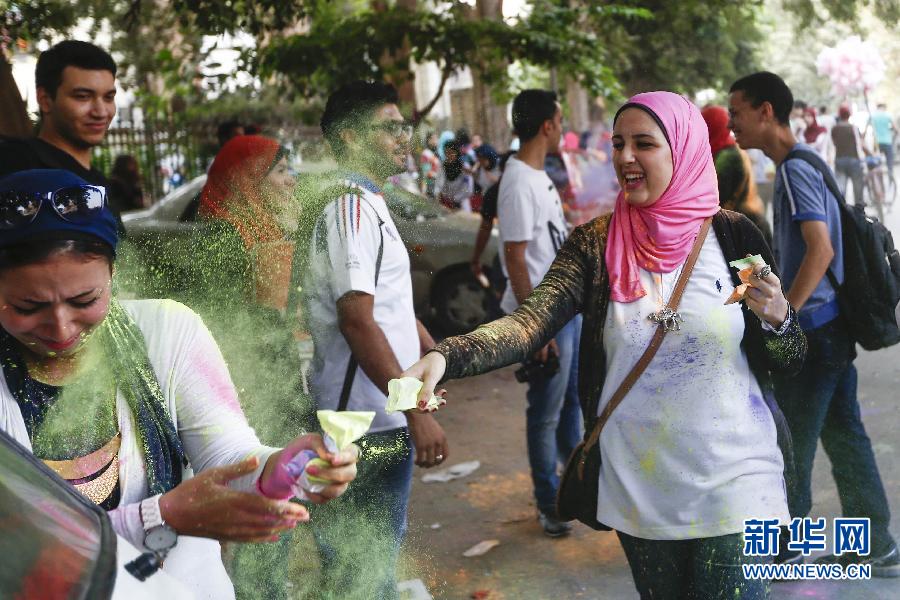 10月16日，在埃及首都開羅，一名女青年在“彩色跑”活動(dòng)中拋撒彩色粉末。