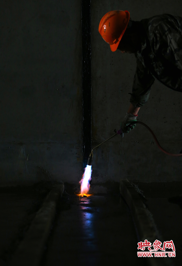 工人師傅用噴槍烘干地面，便于做防水處理