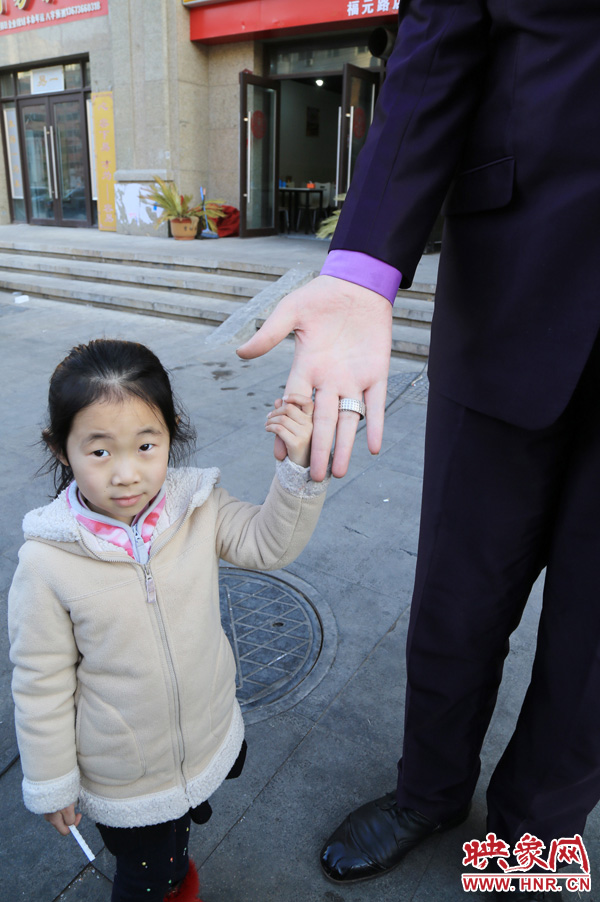 巨人“張歡”牽著一名漂亮的小女孩，兩人的手大小對(duì)比非常明顯。