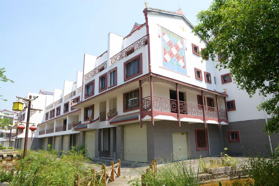 2016年7月26日，村民在廣西來賓市忻城縣隆達(dá)山水福城荒廢別墅間放牛。