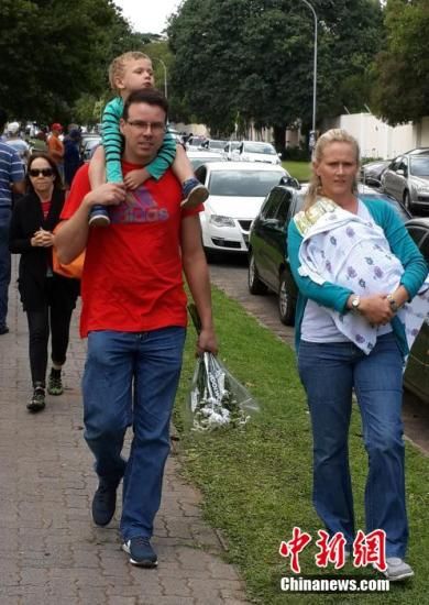 圖為一個(gè)白人家庭，由父母帶著孩子到曼德拉家門(mén)外悼念。中新社發(fā) 宋方燦 攝