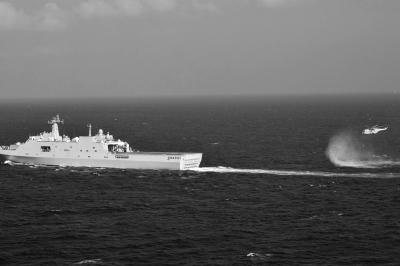 11日，抵達馬航飛機失聯(lián)海區(qū)的海軍井岡山艦與艦載直升機協(xié)同展開立體搜救行動。新華社發(fā)