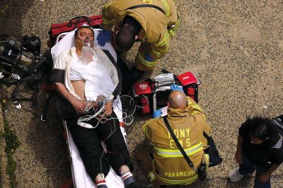 2日，救援人員在美國(guó)紐約地鐵事故車(chē)輛內(nèi)緊急疏散一名受傷乘客。圖/CFP