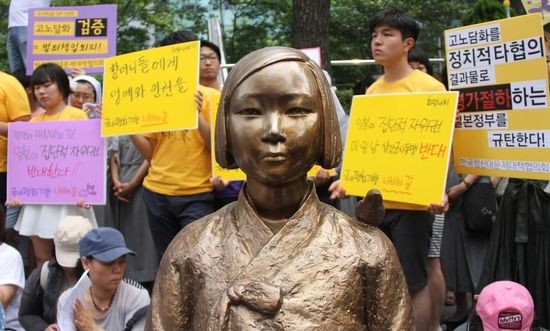 7月2日，在韓國(guó)首爾的日本駐韓國(guó)大使館前，民眾在慰安婦少女像旁手持標(biāo)語(yǔ)參加抗議活動(dòng)。