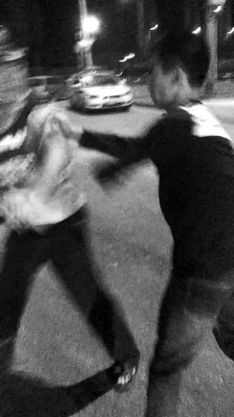 一名男子扯著民警的反光背心一路追打。